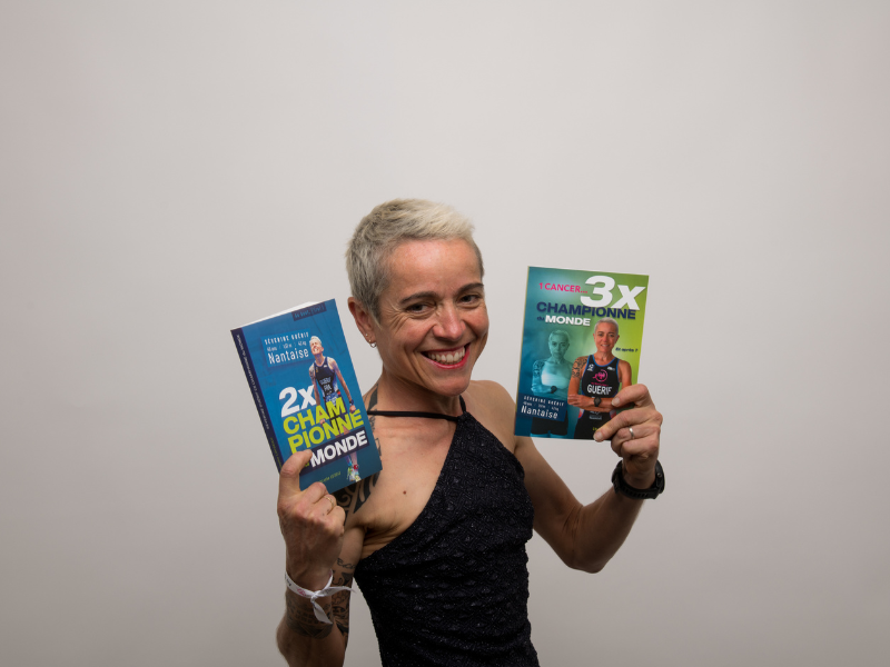 Séverine Guérif souriante en portrait rapproché, tenant les deux livres de chaque côté de son visage pour mettre en avant les couvertures et son image d’auteure et d’athlète.